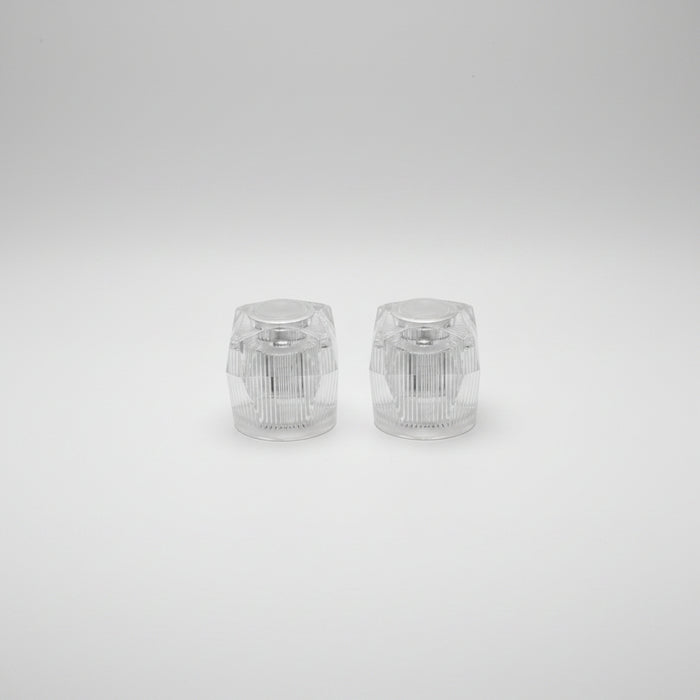 A pair of clear, crystal-like faucet handles designed for hot and cold water control.